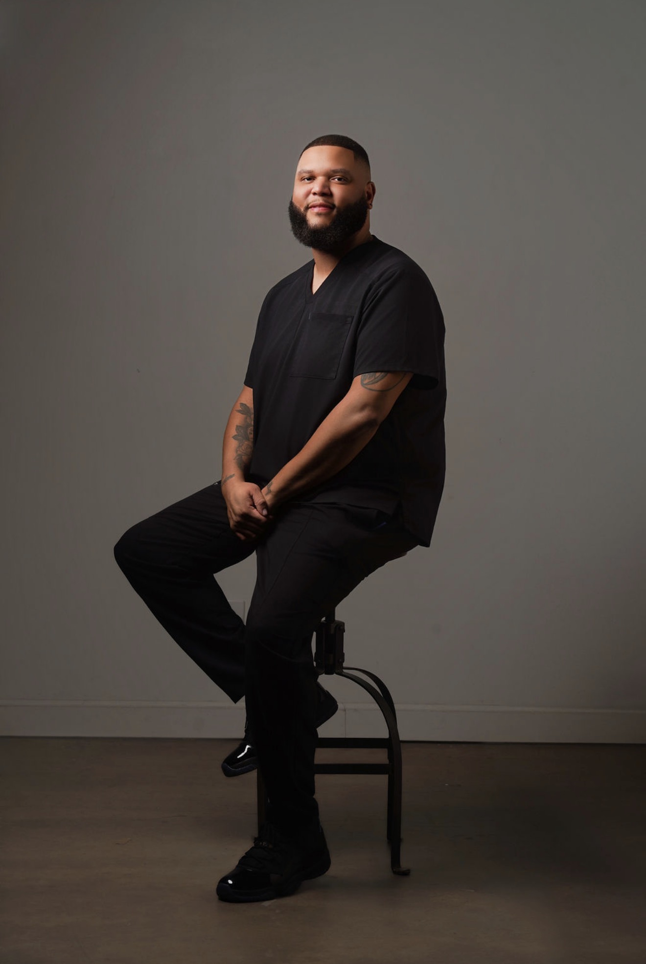 Man in black scrubs sitting.